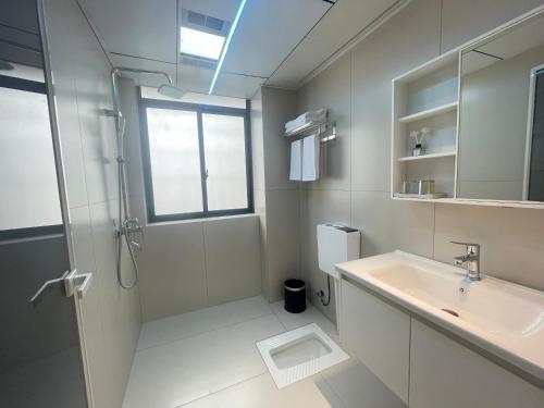 a white bathroom with a shower and a sink at 笑涡SmileNest Downtown Luxury Suite for 2-10 Guests, Zhangjiajie Attraction Ticket Service, Ideal for Couples, Families & Groups in Zhangjiajie