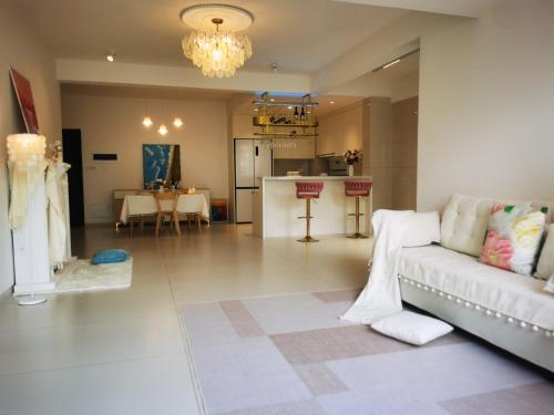 a living room with a white couch and a kitchen at 笑涡SmileNest Downtown Luxury Suite for 2-10 Guests, Zhangjiajie Attraction Ticket Service, Ideal for Couples, Families & Groups in Zhangjiajie