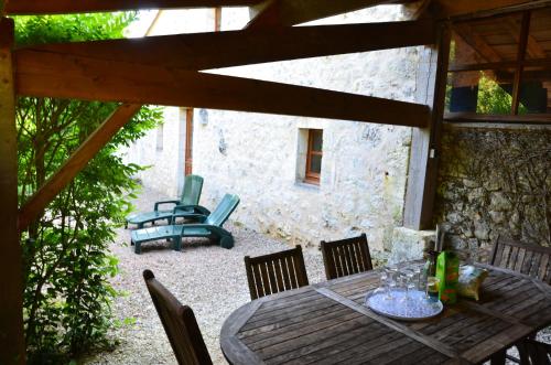 a wooden table and chairs on a patio at Logis de Flamenac in Pranzac