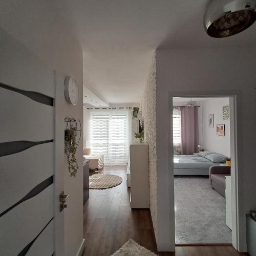 a living room with a bed and a hallway at Apartament Sikorskiego, klimatyzacja, parking monitoring in Suwałki