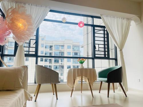 a living room with a table and a large window at 笑涡SmileNest Downtown Luxury Suite for 2-10 Guests, Zhangjiajie Attraction Ticket Service, Ideal for Couples, Families & Groups in Zhangjiajie
