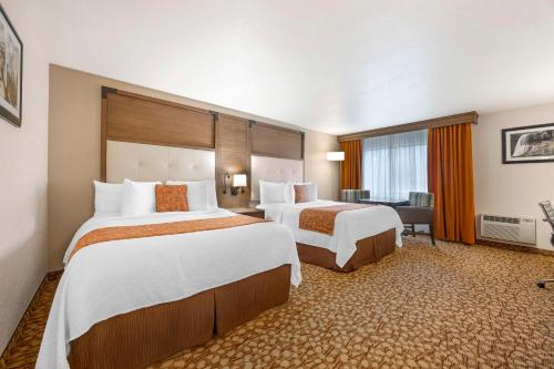 a hotel room with two beds and a desk at Best Western Plus Mill Creek Inn in Salem