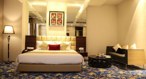 a hotel room with a bed and a chair at The Vivaan Hotel & Resorts Karnal in Karnāl