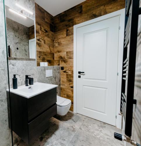 a bathroom with a white sink and a toilet at Evo Residence Taietura Turcului in Cluj-Napoca