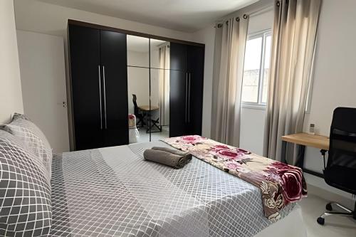 a bedroom with a bed with a white blanket on it at 3 Quartos com Ar | 2 Vagas | Próx. Quiero Café in Meia Praia