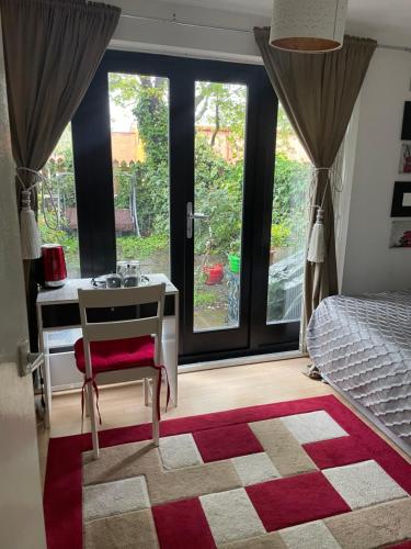 a bedroom with a desk and a bed and a window at Charming Bedroom with Garden in London