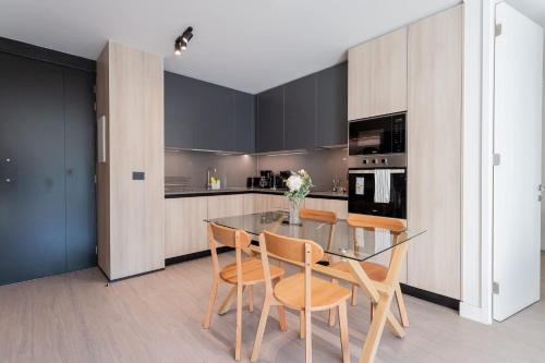 a dining room with a glass table and chairs at Enjoy the Space 2BR 2BA Parque Araucano Sector in Santiago