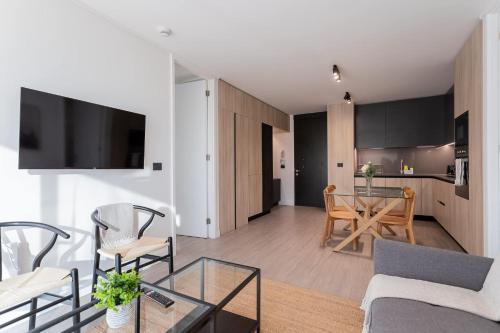 a living room and kitchen with a table and chairs at Enjoy the Space 2BR 2BA Parque Araucano Sector in Santiago