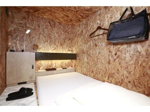 東京にあるeeGee STAY Kamata"Capsule room only" - Vacation STAY 25672vのベッドと壁にテレビが掛かった寝室