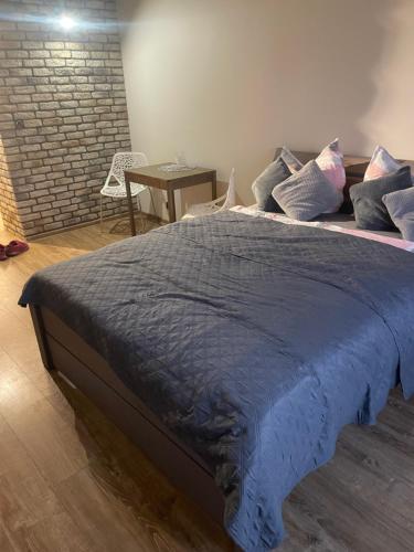 a bed with a blue comforter and pillows on it at studio Szymanowskiego 5 in Szczecin