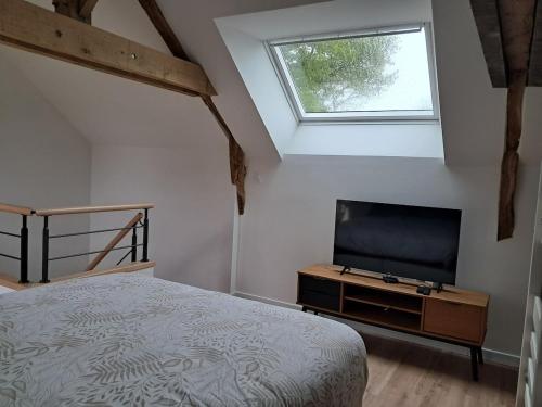 une chambre avec un lit et une télévision à écran plat dans l'établissement Au calme à la campagne 13 pers, à La Mézière