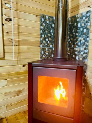 a wood stove with a fire in a room at Cabañas Maco in Ranco