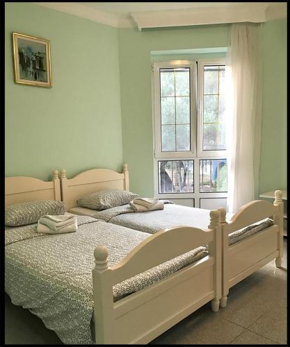 two twin beds in a bedroom with a window at Villa VIktoria in Petrovac na Moru