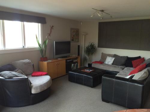 un soggiorno con due divani e una TV di English Tudor House a Hamilton