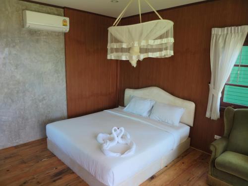 a bedroom with a white bed with a heart decoration on it at Bangbaobeach Resort in Ko Chang
