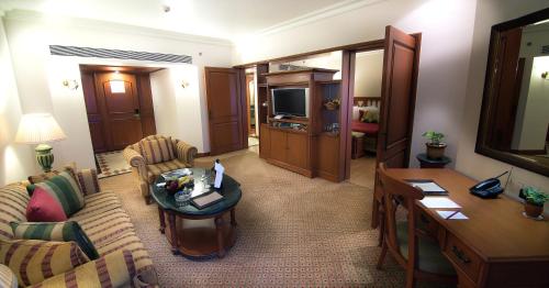 a living room with a couch and a table at The Orchid Hotel Mumbai Vile Parle in Mumbai