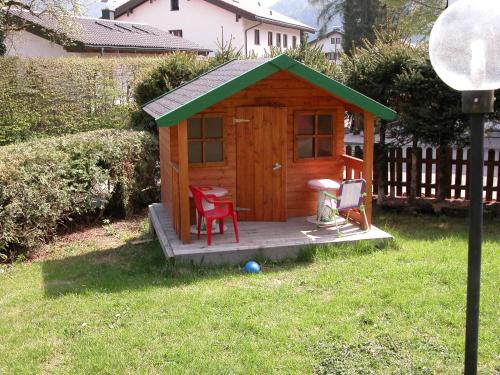 a wooden cabin with a table and two chairs in a yard at Hotel-Restaurant Zum Hirschhaus Inklusiv Chiemgaukarte in Ruhpolding