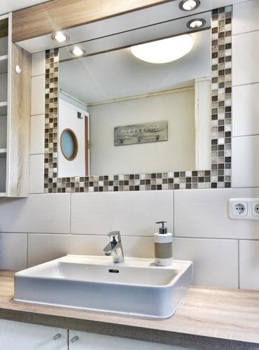 a bathroom with a white sink and a mirror at Urlauberschiff Neptun im Ostseebad Prerow in Prerow