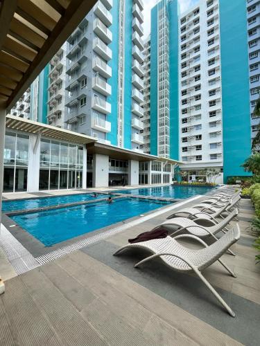 a swimming pool with lounge chairs in front of a building at Sleek Stay in Bacolod in Bacolod