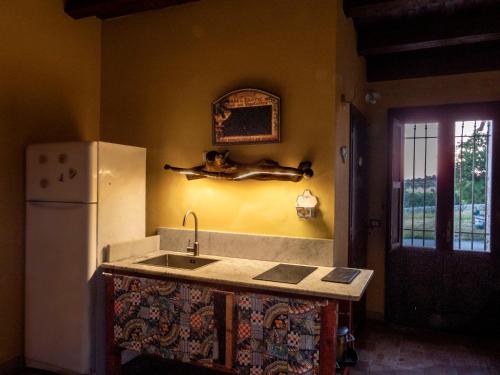 a kitchen with a sink and a refrigerator at Casa Pizzuta in Noto