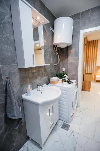a bathroom with a white sink and a mirror at Apartment Vukeljic in Doboj