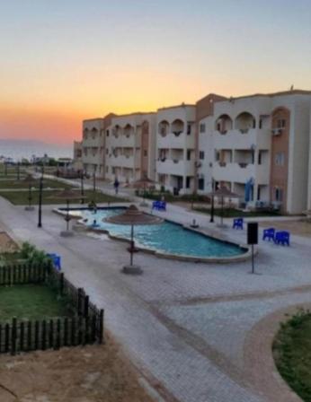 a view of a building with a swimming pool at قرية بلولاجون راس سدر شاليه فاخر للايجار for families only in Ras Sedr