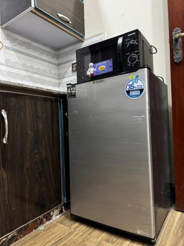 a refrigerator with a television on top of it at Elite Apartments in Gujrānwāla