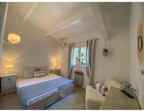 - une chambre blanche avec un lit et un canapé dans l'établissement Maison de vacances, à Cogolin