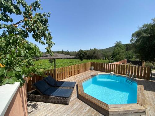 - une piscine dans un jardin avec une clôture en bois dans l'établissement Maison de vacances, à Cogolin