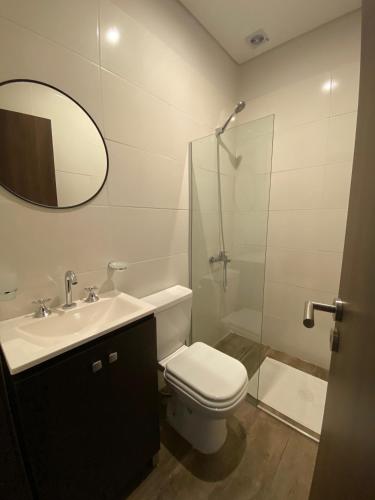 a bathroom with a toilet and a sink and a mirror at Casa Robles in Pilar