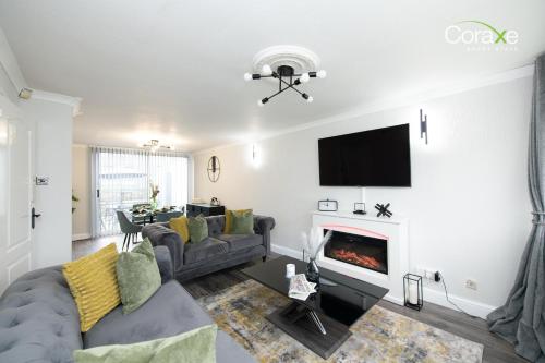 Una sala de estar con un sofá y una chimenea. en Stylish 3BR Home in Rowley Regis, en Rowley Regis