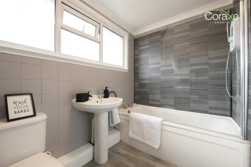 Un baño con lavabo, inodoro y bañera. en Stylish 3BR Home in Rowley Regis, en Rowley Regis
