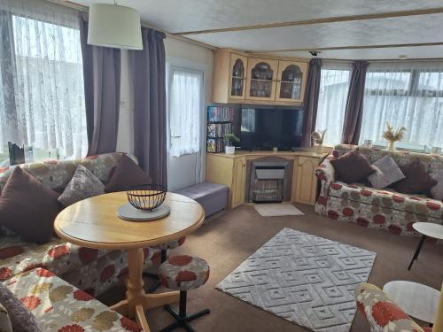 a living room with a couch and a table at Highfield and the Haven Caravan Skegness in Lincolnshire