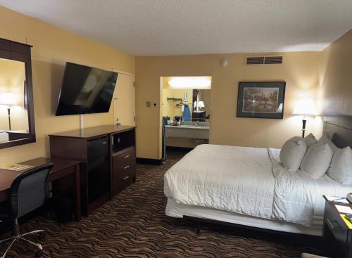 a hotel room with a bed and a flat screen tv at MCM Grande FunDome Odessa in Odessa