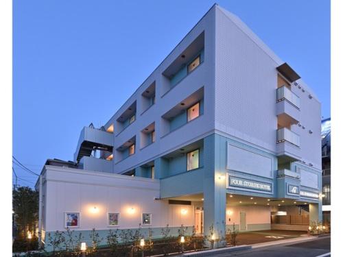 un grande edificio bianco con luci di fronte di FourStoriesHotelMaihama Tokyo Bay - Vacation STAY 73130v a Tokyo