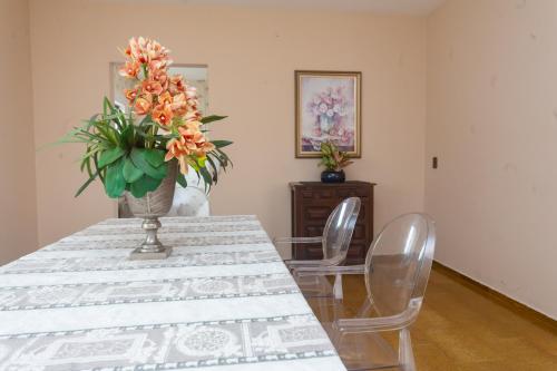 a dining room table with a vase of flowers on it at Apartamento Cidade Araxá in Araxá
