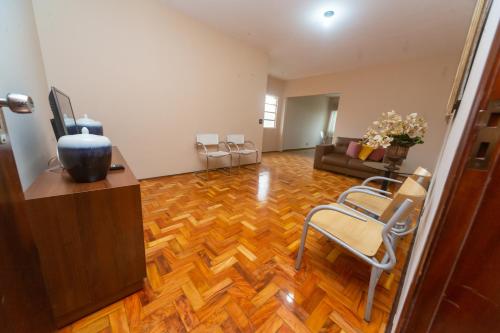 a living room with a wooden floor and a couch at Apartamento Cidade Araxá in Araxá