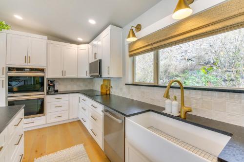 a kitchen with white cabinets and a sink and a window at Peaceful Cabin with Dock on Lake Pend Oreille in Sagle