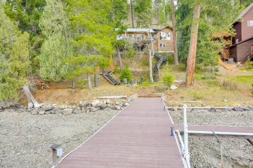 a wooden walkway leading to a house in the woods at Peaceful Cabin with Dock on Lake Pend Oreille in Sagle