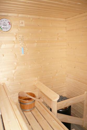 a sauna with a bench and a clock on the wall at Hotel Schepers in Gronau