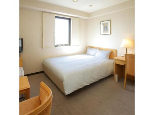 una camera d'albergo con un letto e una scrivania di Smile Hotel Fukuoka Okawa - Vacation STAY 81556v a Ōkawa