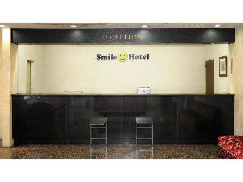 un segno per un hotel sorridente con due sgabelli di Smile Hotel Fukuoka Okawa - Vacation STAY 81556v a Ōkawa