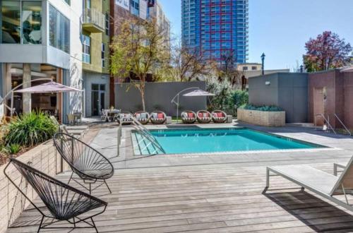 a patio with a swimming pool and chairs next to a building at Charming 3 Bedroom Apartment with Pool Near San Diego Convention Center in San Diego