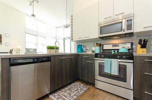 a kitchen with a stove and a microwave at Charming 3 Bedroom Apartment with Pool Near San Diego Convention Center in San Diego