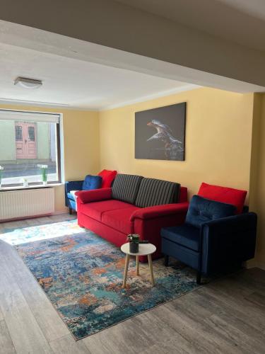 a living room with a red couch and blue chairs at Yellow Home in Lychen