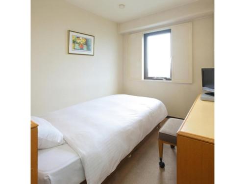 a room with a bed and a desk and a television at Smile Hotel Fukuoka Okawa - Vacation STAY 80017v in Ōkawa