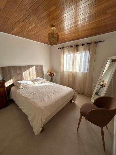 a bedroom with a large bed and a wooden ceiling at Maison typique de village in Sorbo-Ocagnano