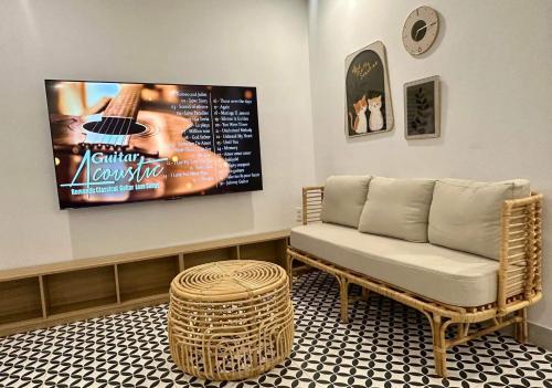 a living room with a couch and a flat screen tv at GG Garden Home in Bao Loc