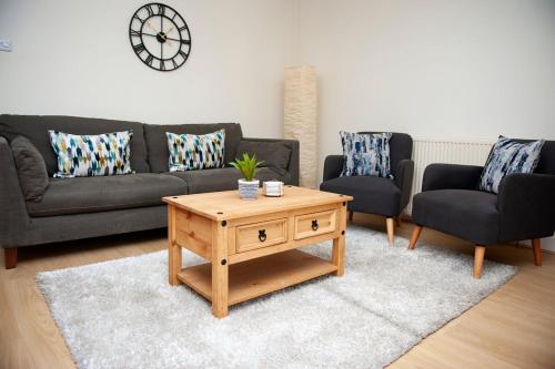 a living room with a couch and a coffee table at Fresh and spacious 3 bedroom home in Angus