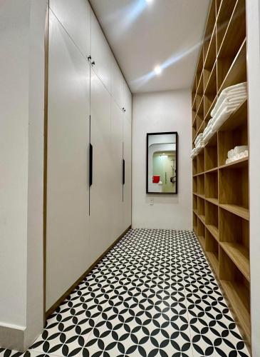 a hallway with white walls and a black and white tile floor at GG Garden Home in Bao Loc